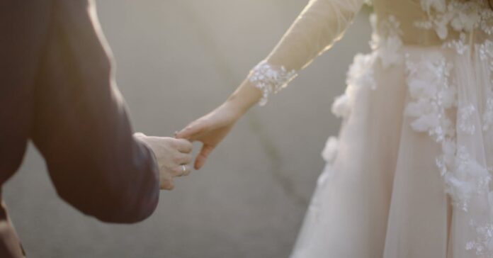 A tender moment captured of a bride and groom holding hands, symbolizing love and togetherness.